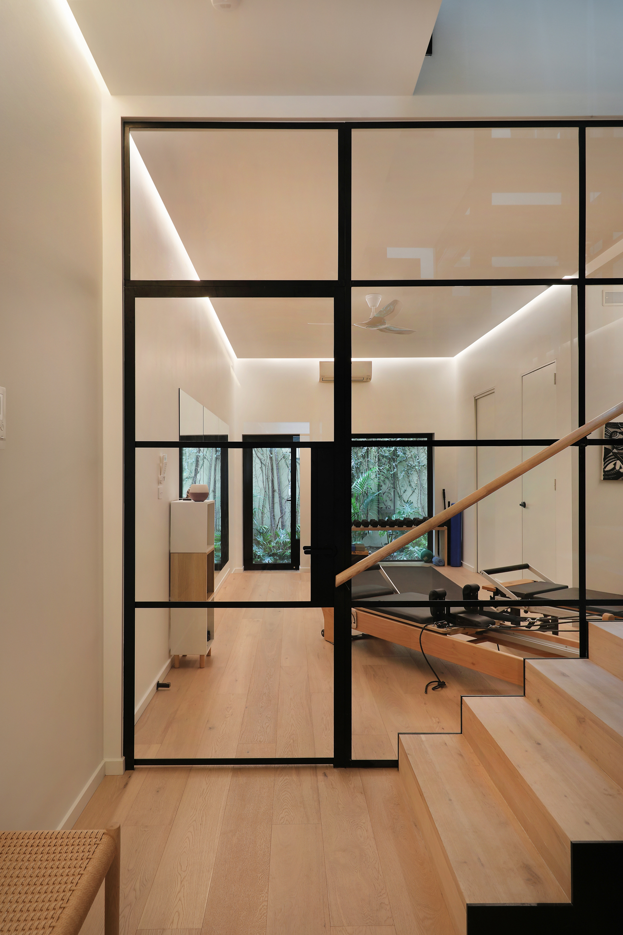 Pilates studio with reformer beds and black steel-framed glass wall, George Street Fitzroy — Eco Building Design