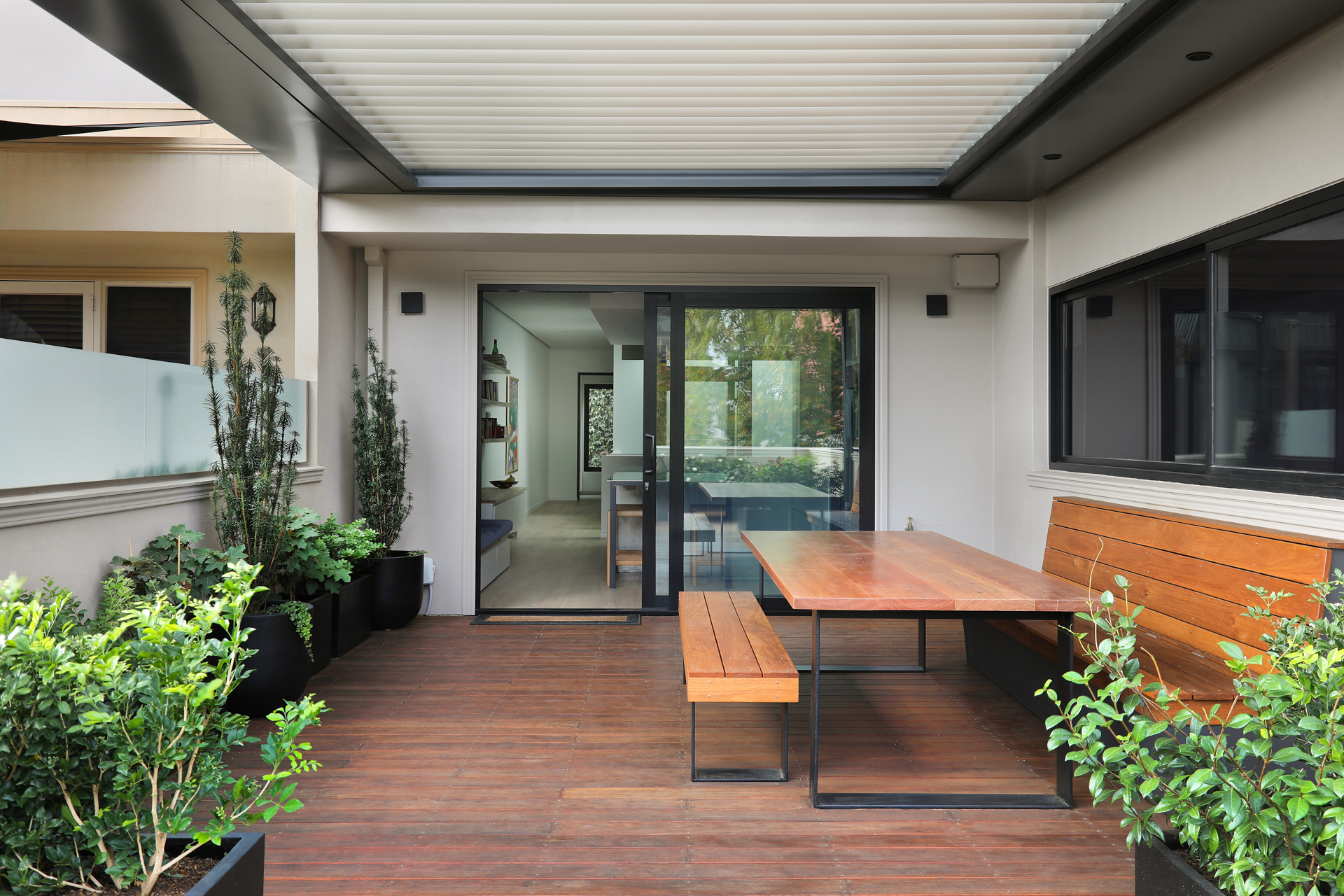 Rooftop deck with louvre pergola, timber dining and established planters, George Street Fitzroy