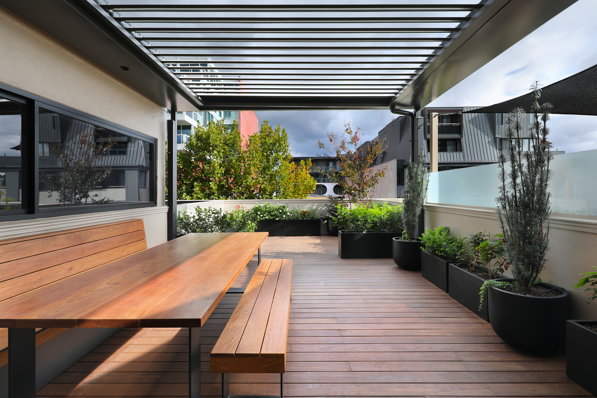 Rooftop terrace with timber dining setting and louvre pergola, George Street Fitzroy — Eco Building Design